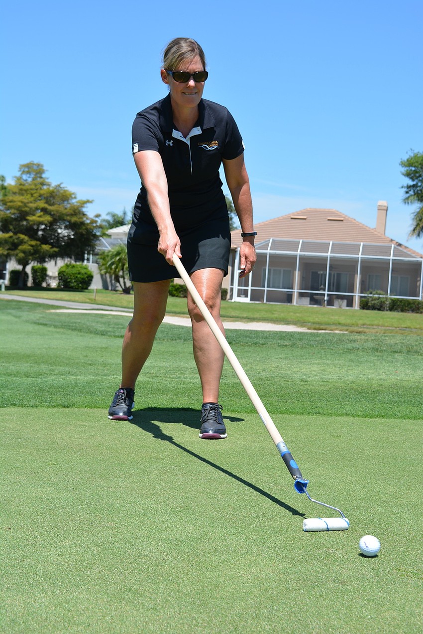 Shelly McAvoy, of sponsor Cooper Creek Dental, has the lead on the longest putt using a paint roller.