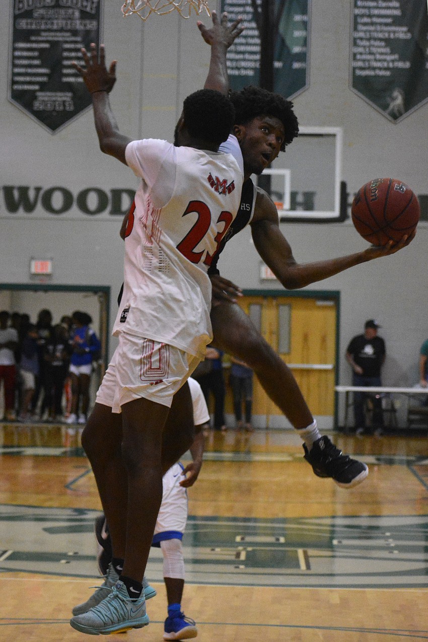 Booker's Jordan Clark sneaks a hot around Manatee defender De'Von Heaven.