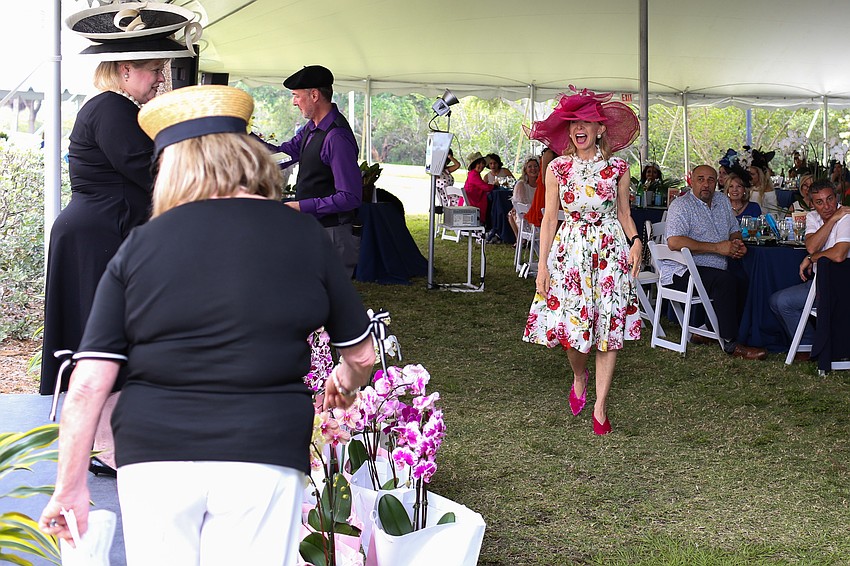 Charlie Ann Syprett walks up to collect her prize for winning best wide-brimmed hat.