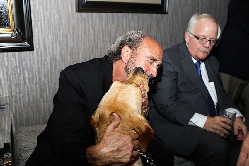 Phil Chaikin gets kisses from Ambassador dog Astro.