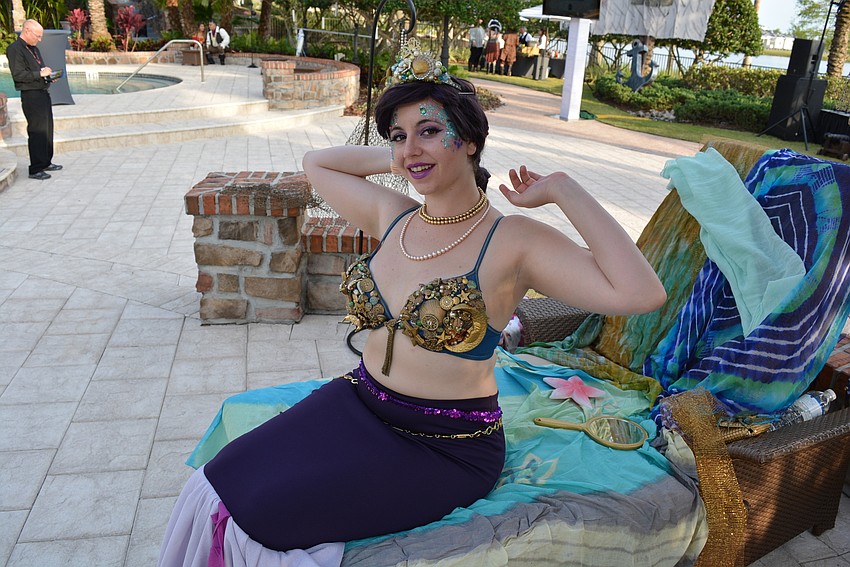Deena Haye, a mermaid, lounges by the pool.