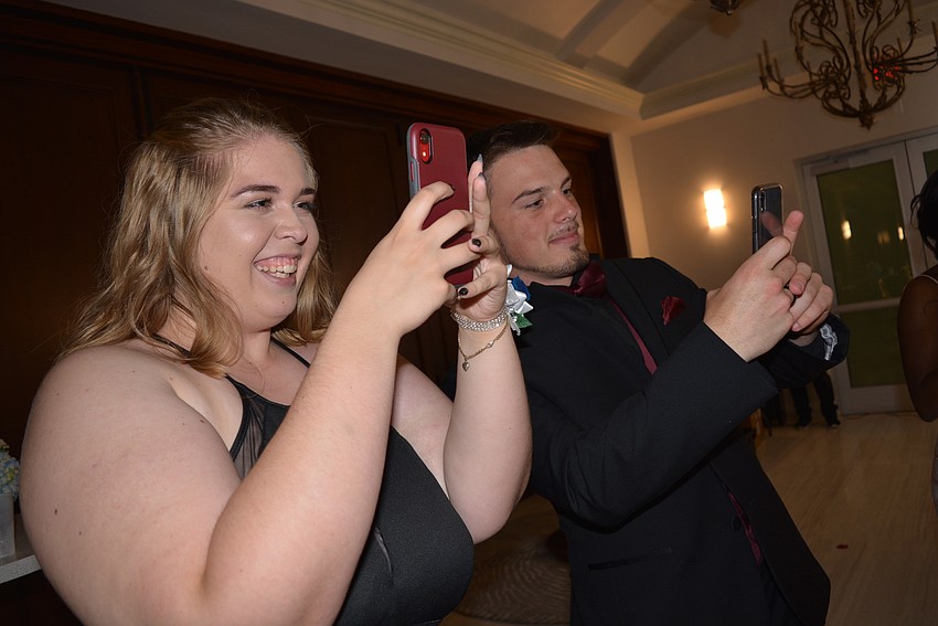 Seniors Erica Cassidy and Josh West snap photos of friends using a 