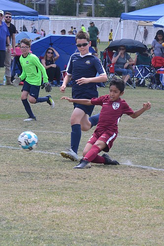 Esteban Vega, 9, slides into a shot on goal for Braden River Soccer Club&#39;s U11 team.