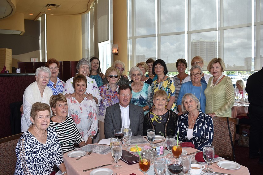 All of the women on the fashion show committee received thanks from Fr. Michael Cannon (center).