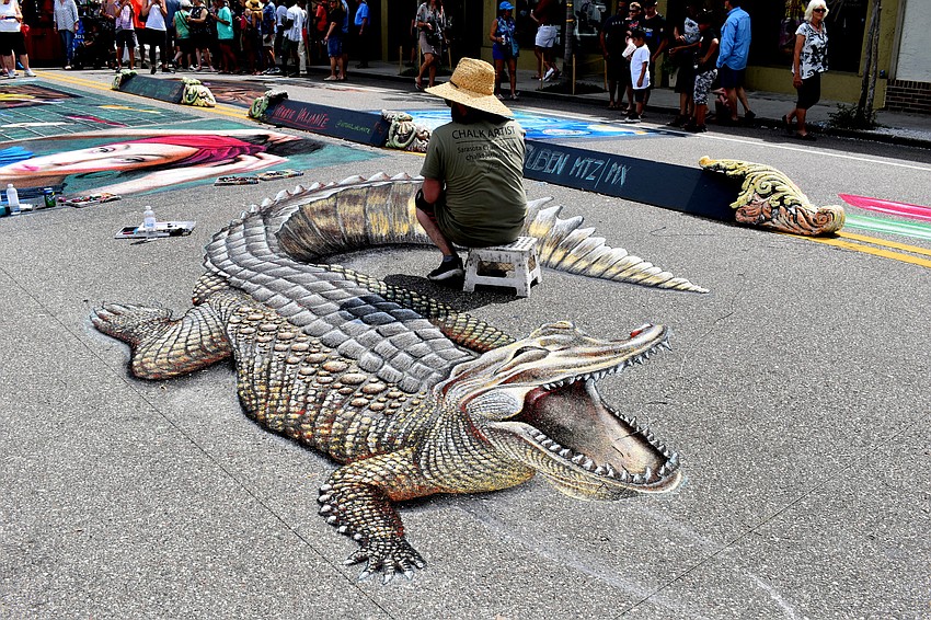 An artist finishes out the scales on his 3D alligator.