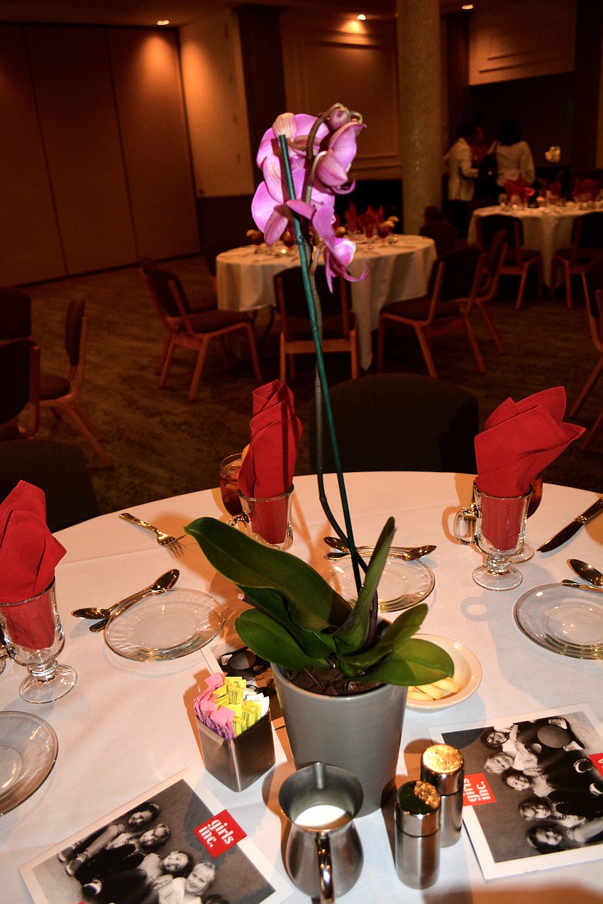 The tables were decorated with red napkins and purple orchids