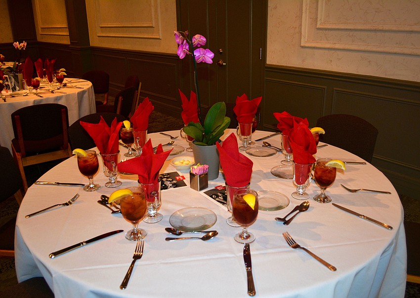The tables were decorated with red napkins and purple orchids