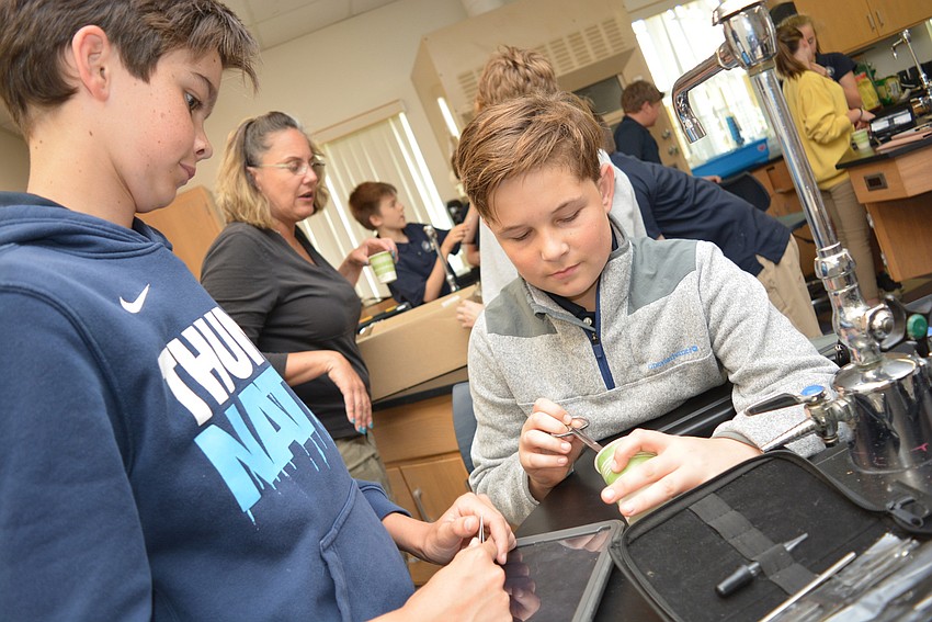 Nick Sparma and Luke Flanders try to pull a pea out of a block of gelatin.