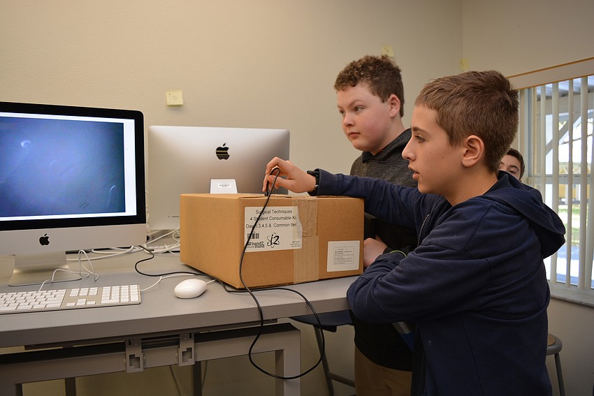 Twelve-year-old Marty Gomien, front, tries to figure out what an animal 