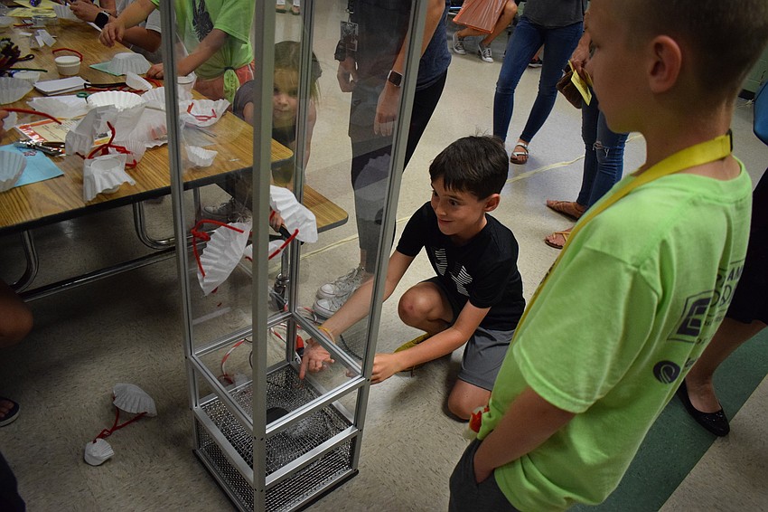Fourth-grader Graham Schlick and third-grader Egor Obukhov watch their creations fly up in a wind tunnel, which was meant to simulate weather balloons.
