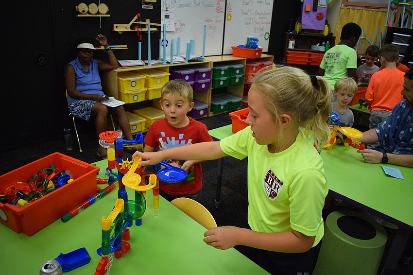 Siblings Abby (fifth grade) and Drew (first grader) Frint build a marble track together.