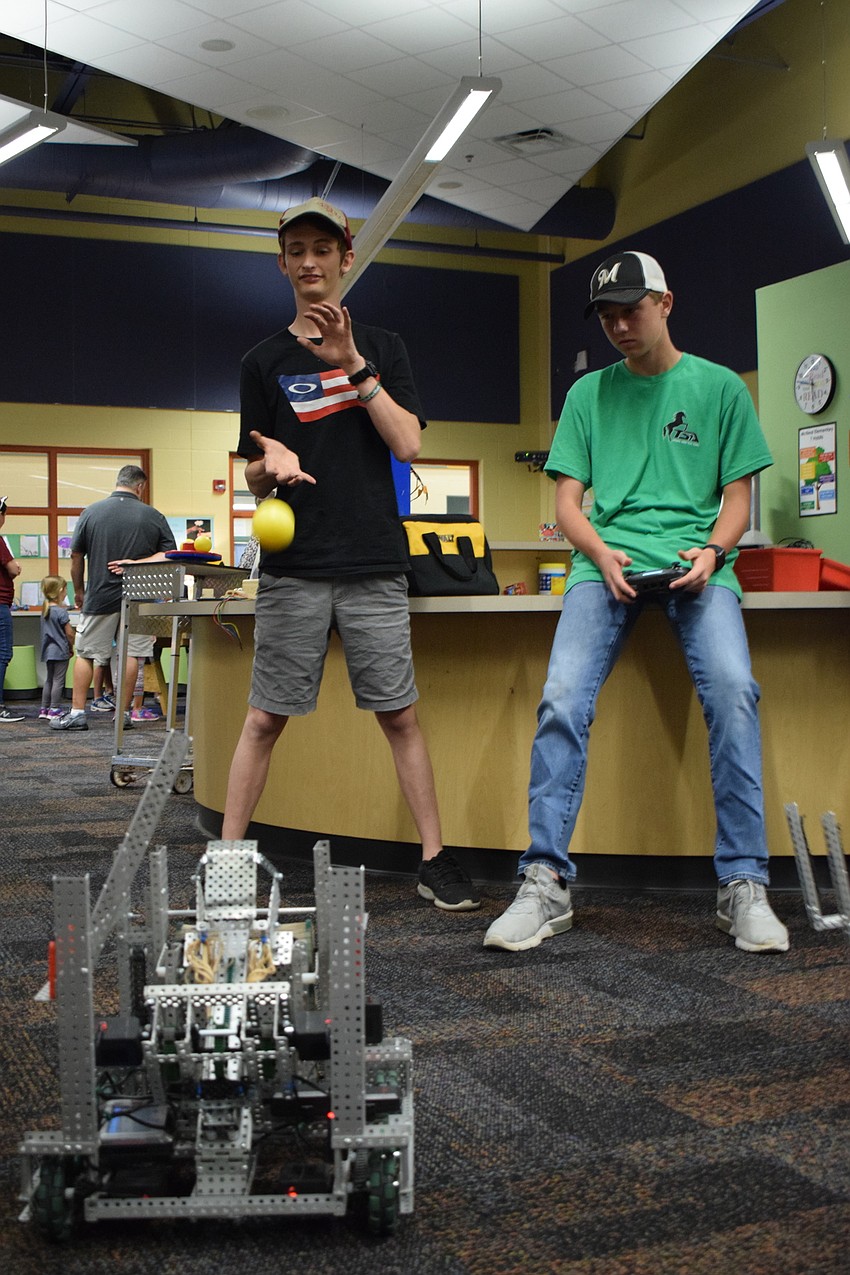 Lakewood Ranch junior Connor Schrand catches a ball launched by a robot piloted by freshman Zach Geiger.