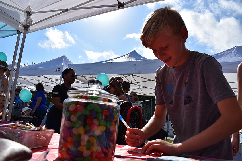 Greenbrook resident Joey Promen takes a guess at how many jelly beans are in the jar at the Observer Media Group tent.