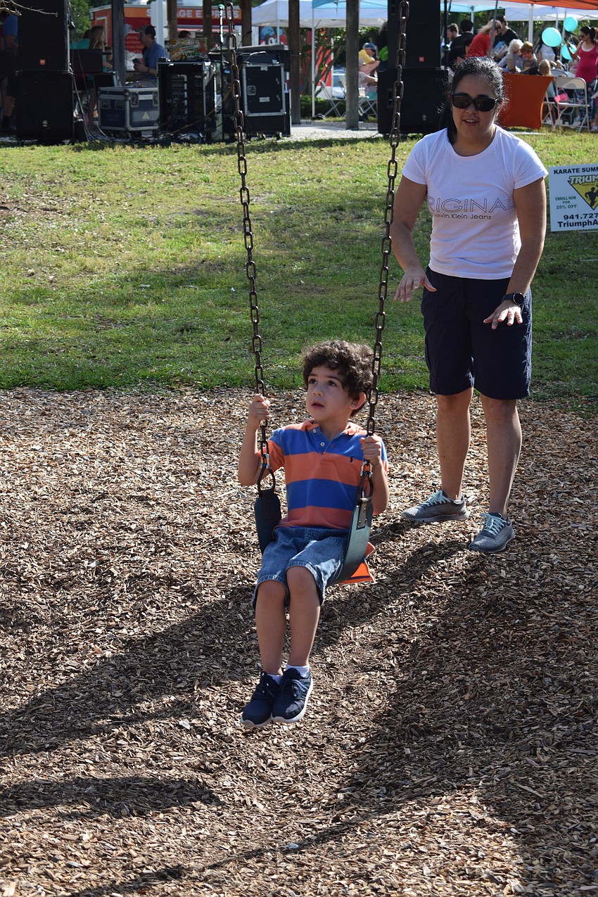 West Bradenton resident Lucian Gutschow pushes her son, Noah, in a swing.