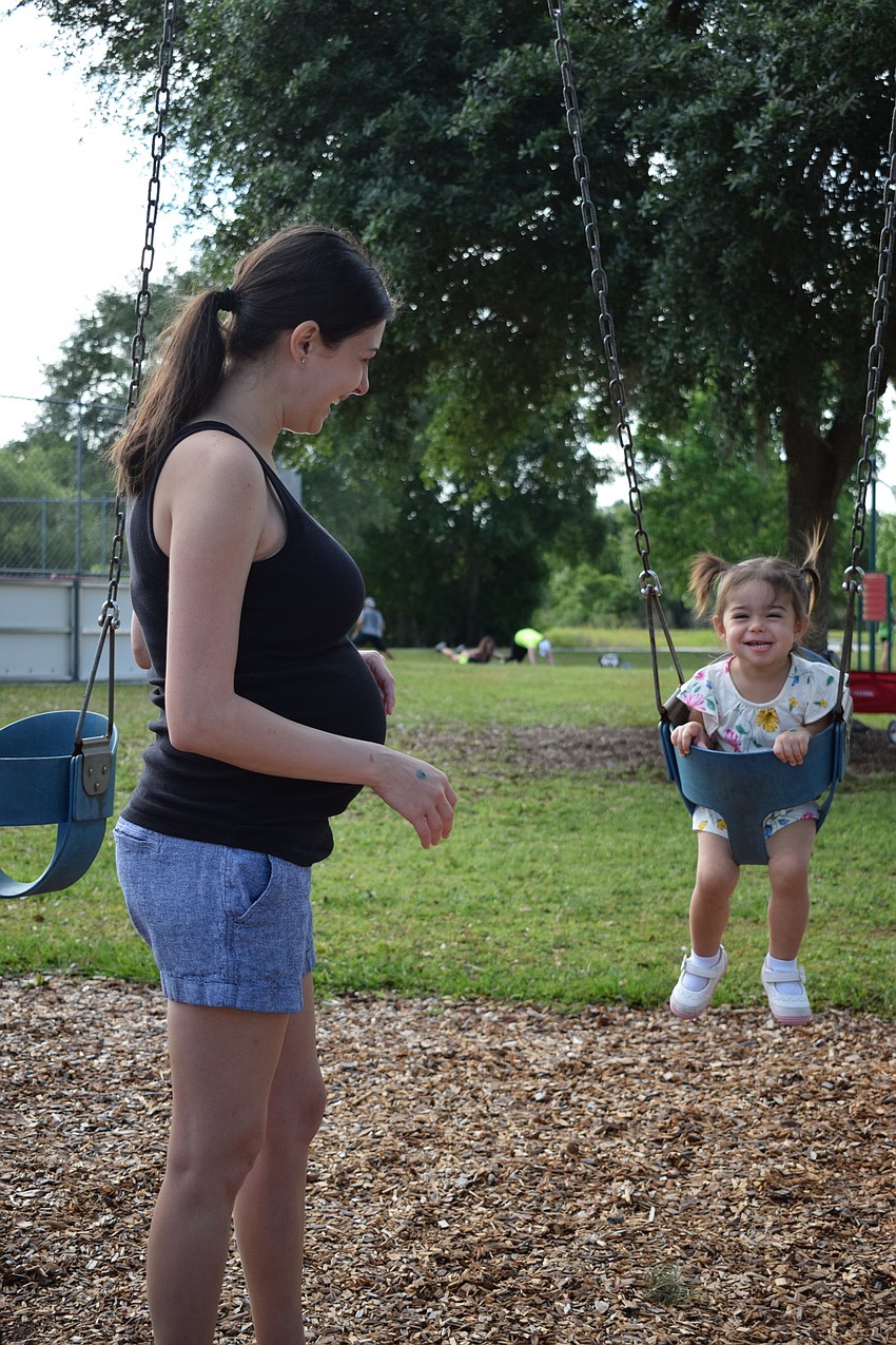 Arbor Grande resident Michelle Ruck pushes her daughter, Eliana, in a swing as the young gal giggles.