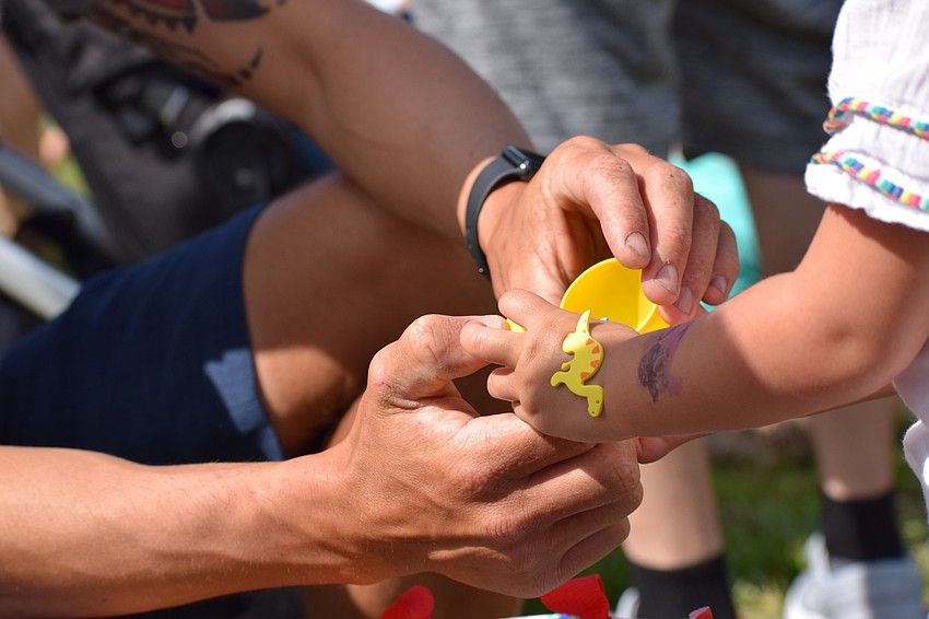 North Port resident Rustaam Hurd helps young Milena open an egg before the K9-Unit's show.