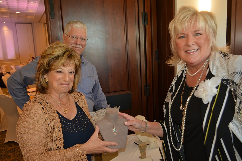 Deb Ficarola of Vanessa Fine Jewelry shows some of the beautiful items on display with Maribeth Phillips of Meals on Wheels Plus. Looking on is Vanessa Fine Jewelry co-owner Don Baugh.
