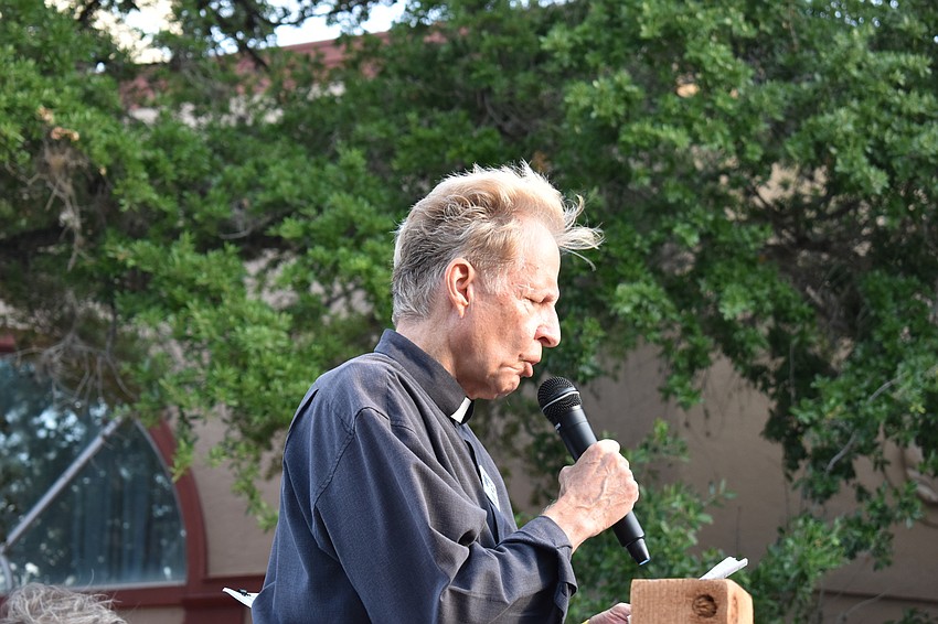 Rev. Dr. Tom Pfaff reads at the first station of the cross.