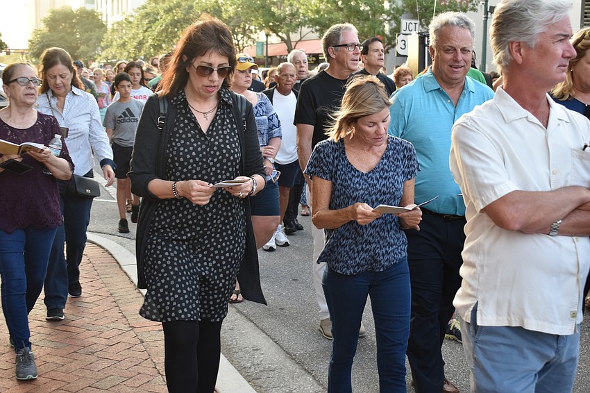Atty Ordonez and Judy Mayo follow along in with the prayers while they walk.