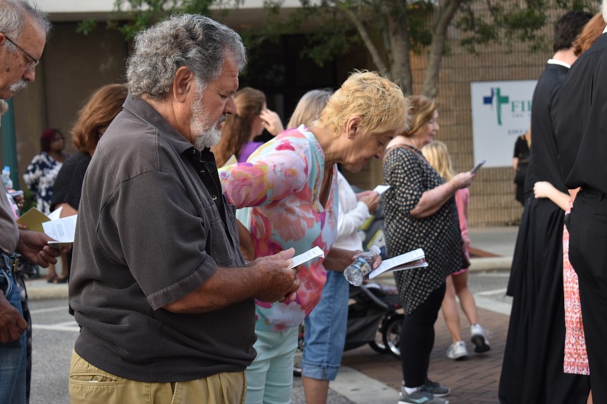 Charles and Marina Paraboschi bow to the cross during the service.