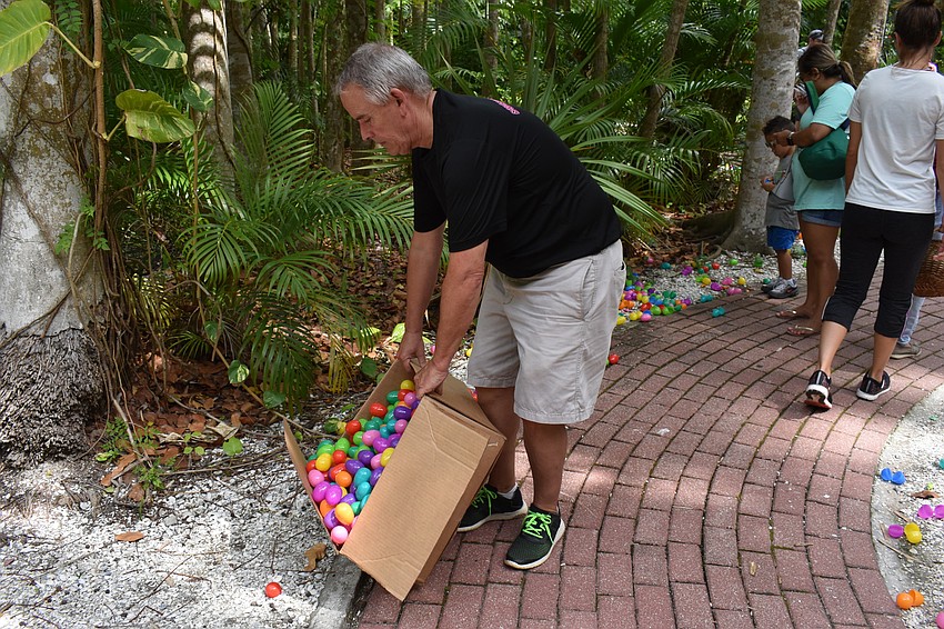 Tim Cincotta pours out more eggs for the children to find.