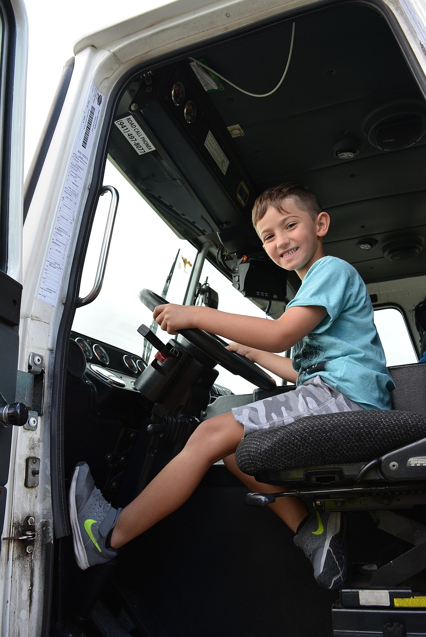 Five-year-old Adrian Fernandez, of Sarasota,  checks out a yard waste truck and tries out the horn.
