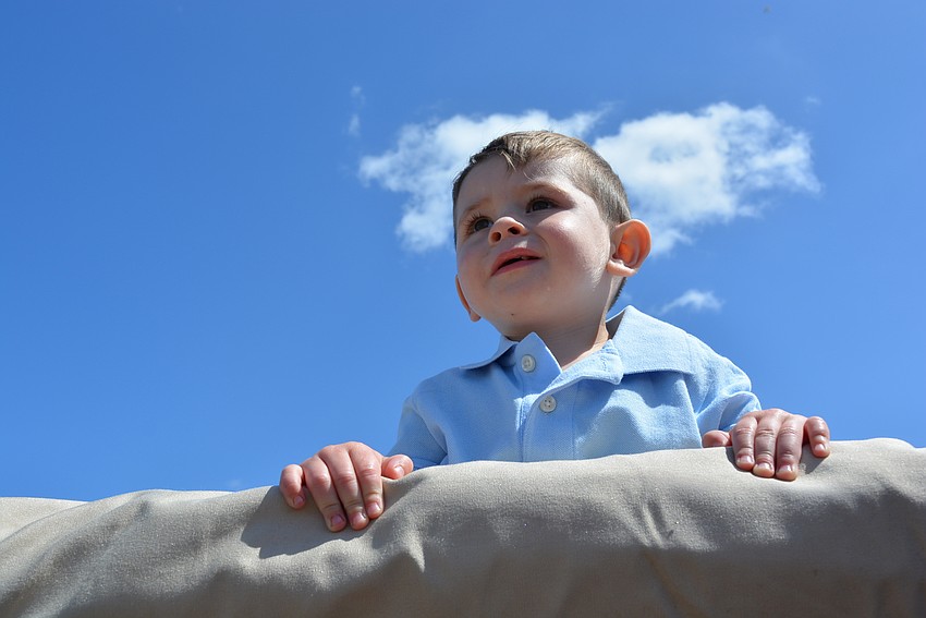 Sarasota resident Jensen Chapman, 19 months, gets a birds-eye view of the trucks from a hayride vehicle.