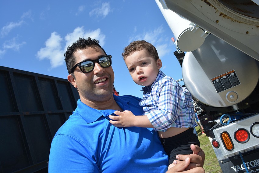 Venice's Mike Baker and his 2-year-old son Greyson try to figure out how the vacuum truck works.