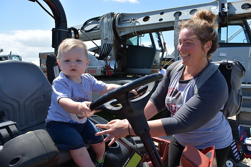 North Port's Mason Barthlow , with  his mom, Melissa Dunbar, tries steering a riding lawn mower.