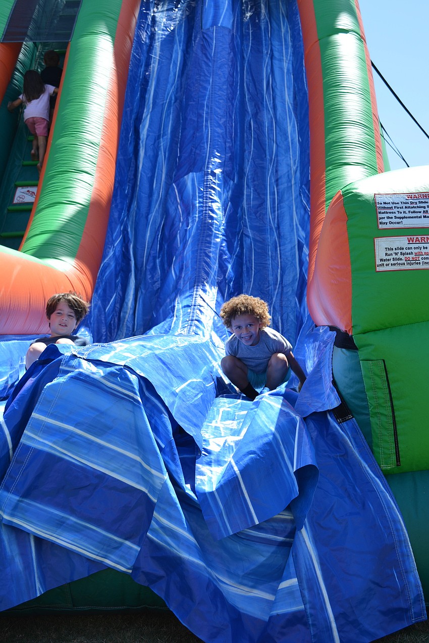 Four-year-old Jordan Wiggins, of Palmetto, zips down the inflatable slide.