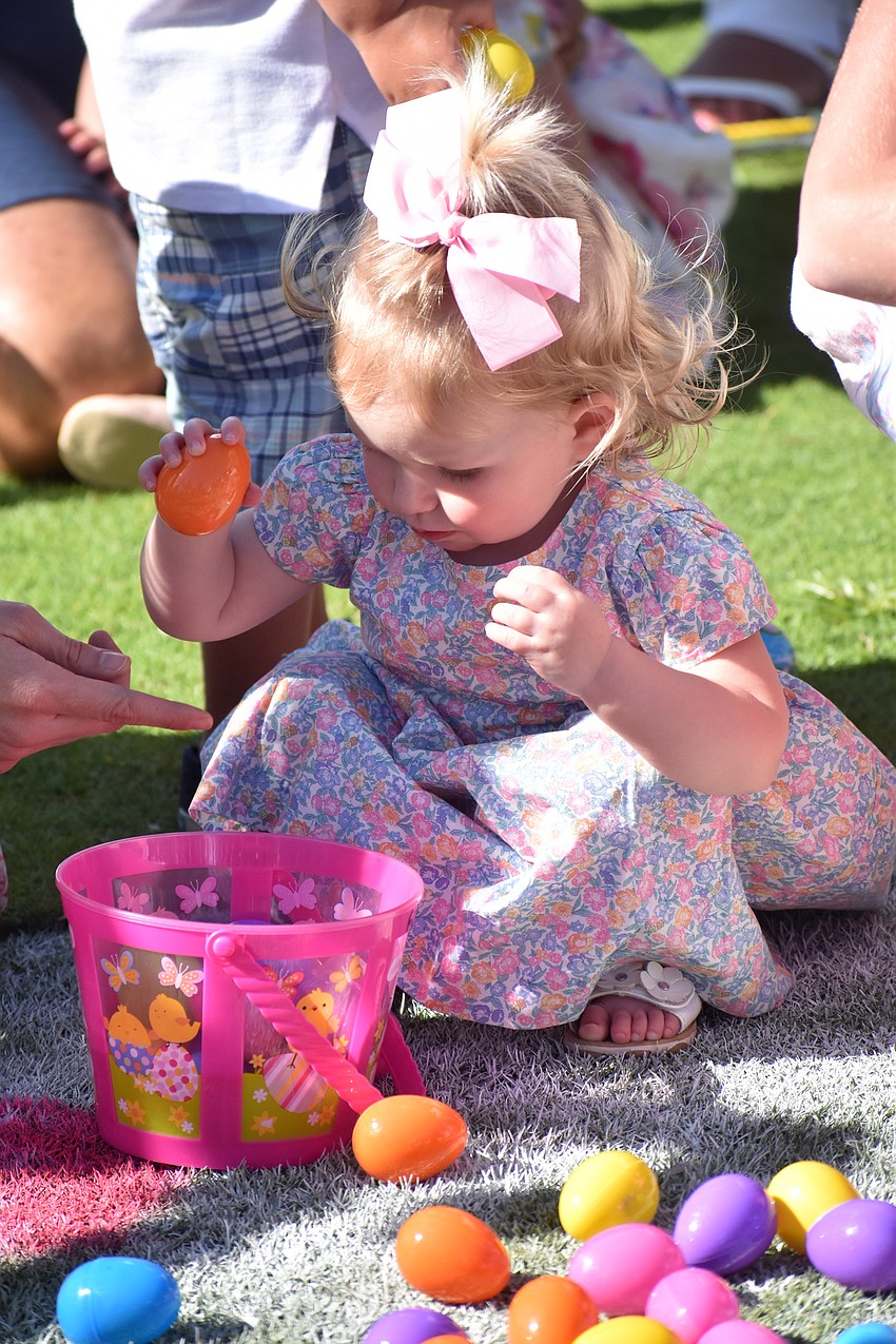 Finley Cullen, 18 months, fills her basket with eggs.