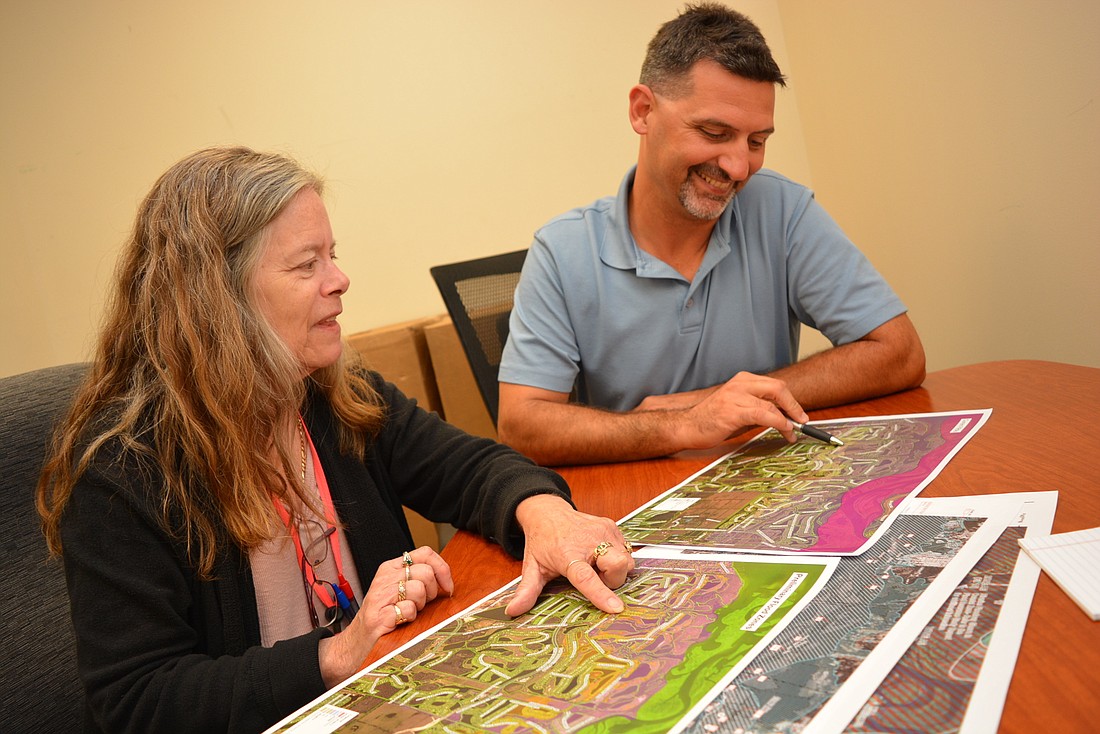 Manatee County Floodplain Section Manager Sandy Tudor and Stormwater Engineering Division Manager Thomas Gerstenberger look at map areas that have changed.