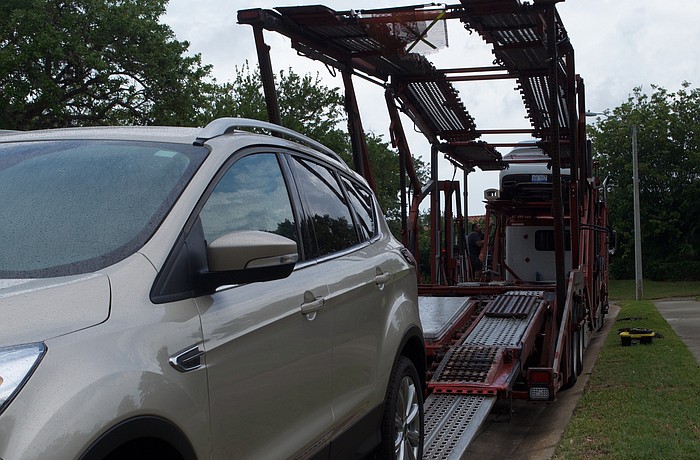 Back to Michigan: A car carrier  was loading up a Longboat Key winter resident&#39;s vehicle for a ride back north.