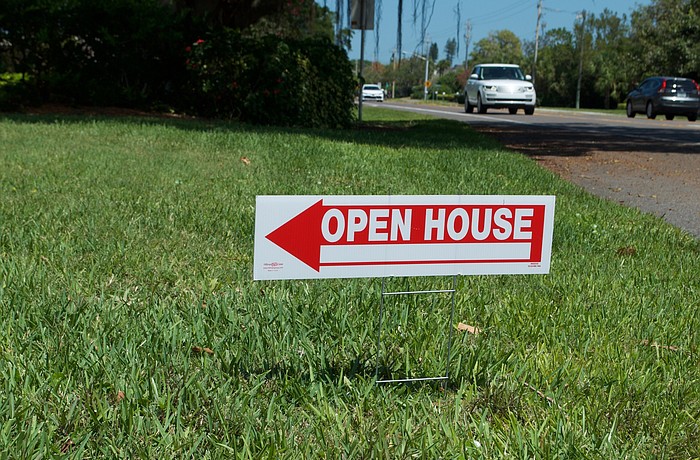 Permitted temporary signs, such as these promoting recent open houses at a condo community on Gulf of Mexico Drive, are 1 square foot.