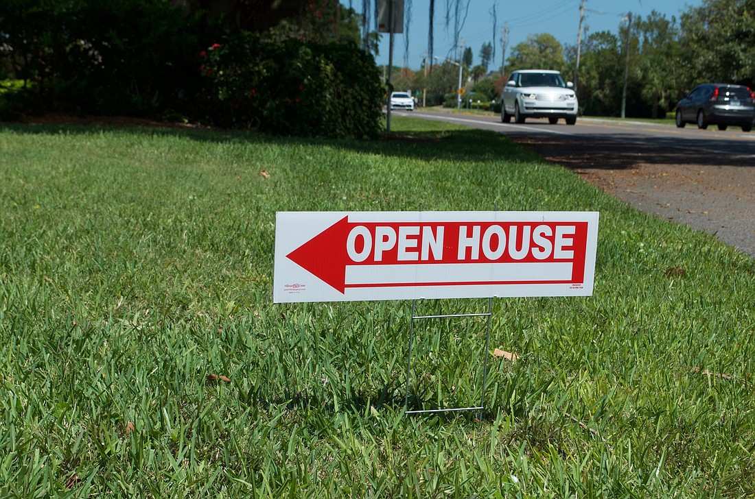 Permitted temporary signs, such as these promoting recent open houses at a condo community on Gulf of Mexico Drive, are 1 square foot.