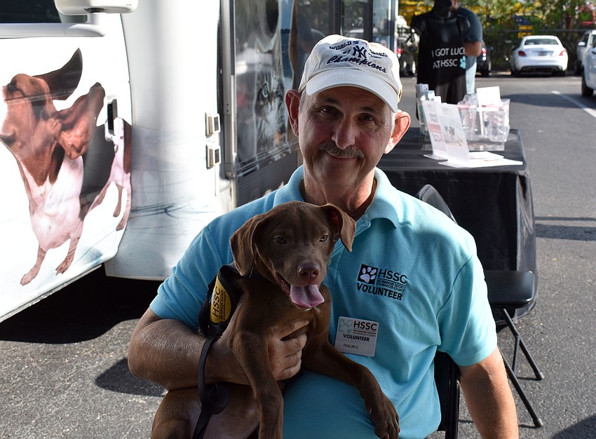 Volunteer Phil Danna holds chocolate lab mix Reese close.