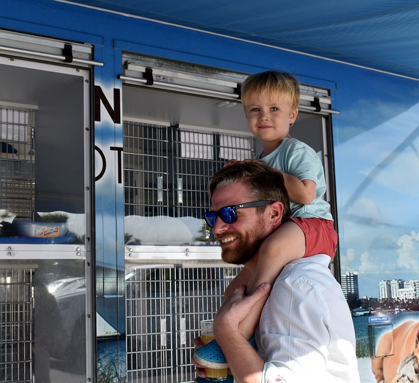 Connor Benson gets a boost from his dad, Brad, so he could see the kittens.