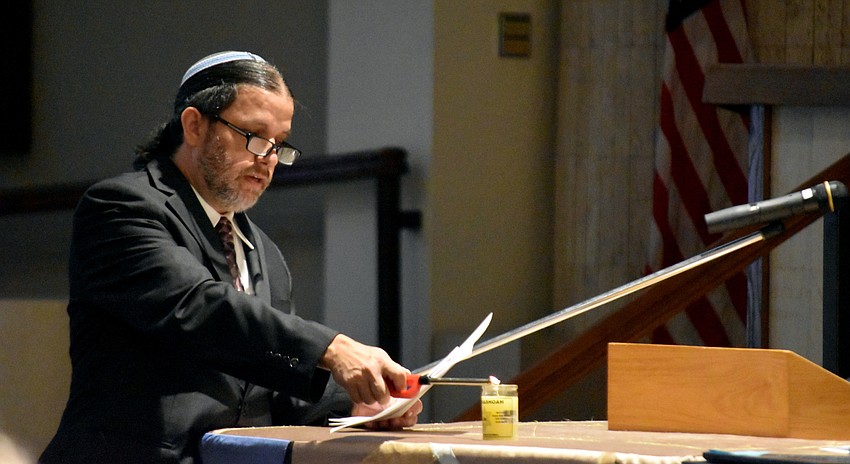 Rabbi Michael Werbow lights the ceremonial yellow candle.