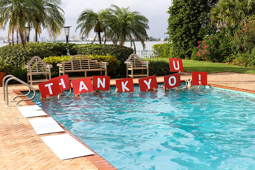 Sarasota YMCA Sharks SASSY Synchronized Swim Team holds up thank you signs during its performance.