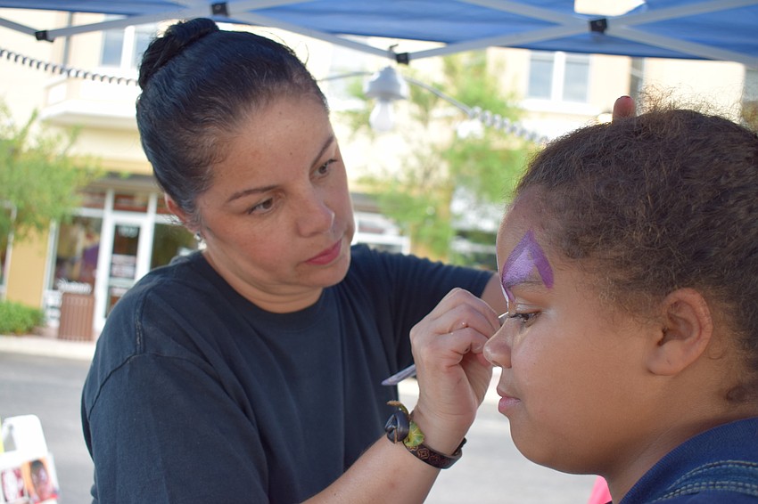 Bradenton's Olivia Glass has her face painted by Monica Vasquez.