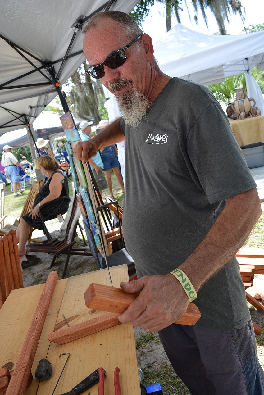 Bradenton's David Brasgalla, owner of WoodScapes, makes Kentucky chairs at his vendor booth.