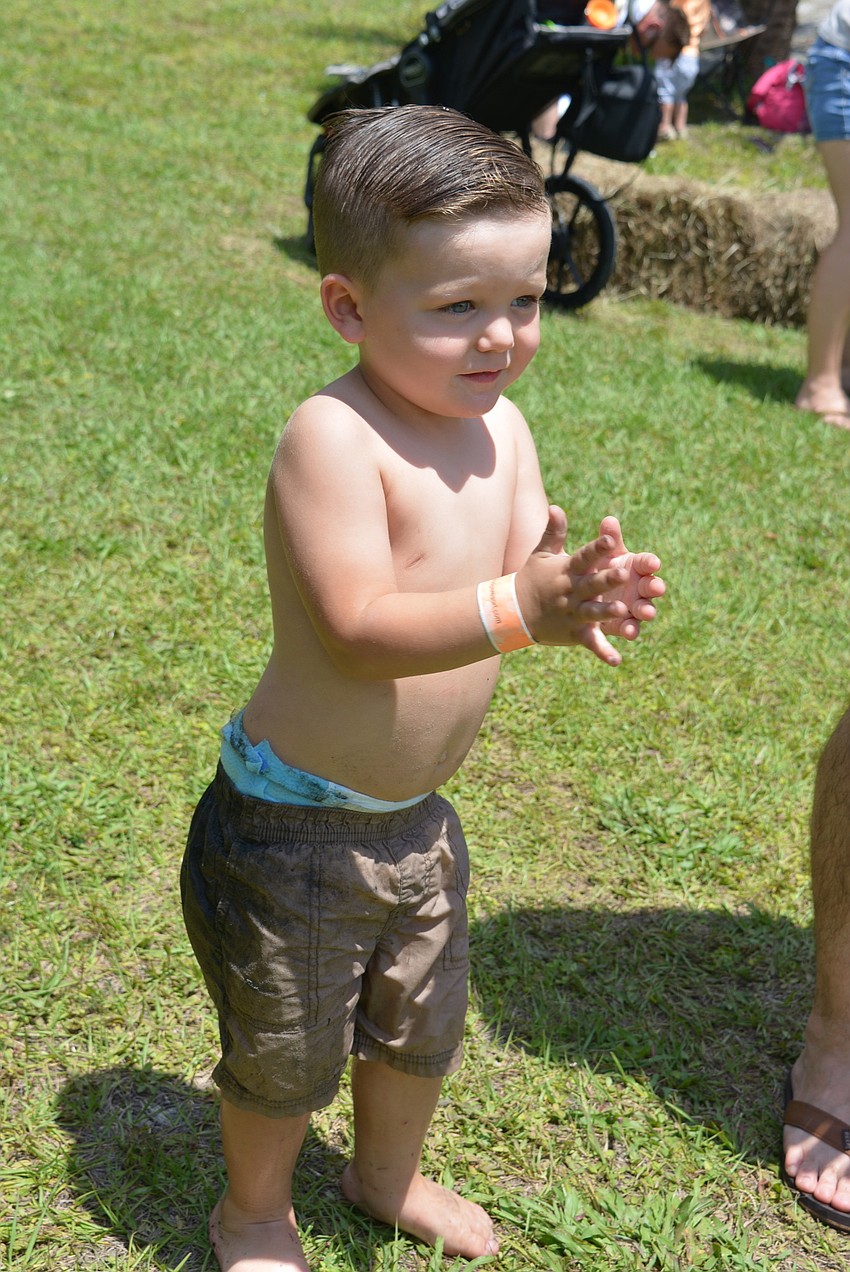 Two-year-old Alexandre Kirland claps for the musicians. He and his family are staying at Linger Lodge RV Resort.