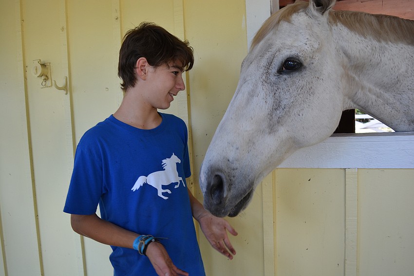 SMART rider Graham Shelton, 14, pets Logan, the horse he usually rides.