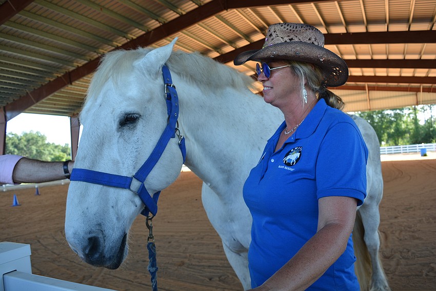 SMART barn manager Samantha Toomey and carriage horse, Sterling, greet guests after a riding demonstration.