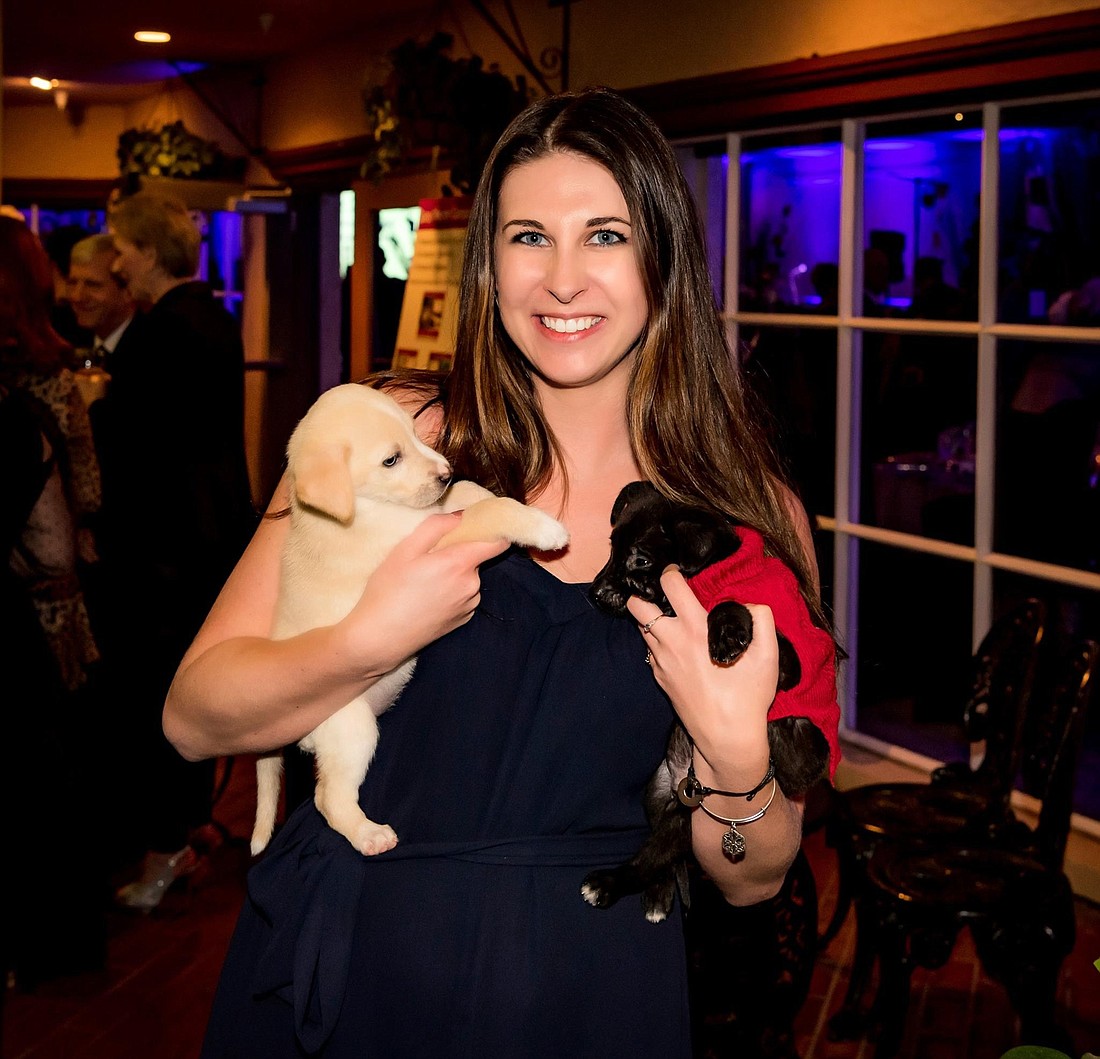 Kayleigh Omang gets some puppy kisses at Animal Rescue Coalitionâ€™s Unconditional Love Gala Feb. 16 at Michaelâ€™s On East.