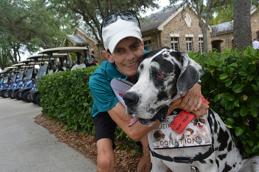 Lakewood Ranch's Merial Graff greets golfers with Matilda, a 4-year-old Great Dane who is a rescue dog.