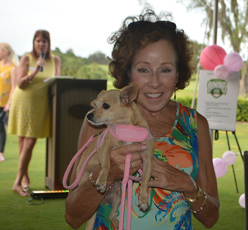 University Park's Anne Gold walks down the red carpet with Katy, a 3-year-old chihuahua-terrier mix after the golf tournament.