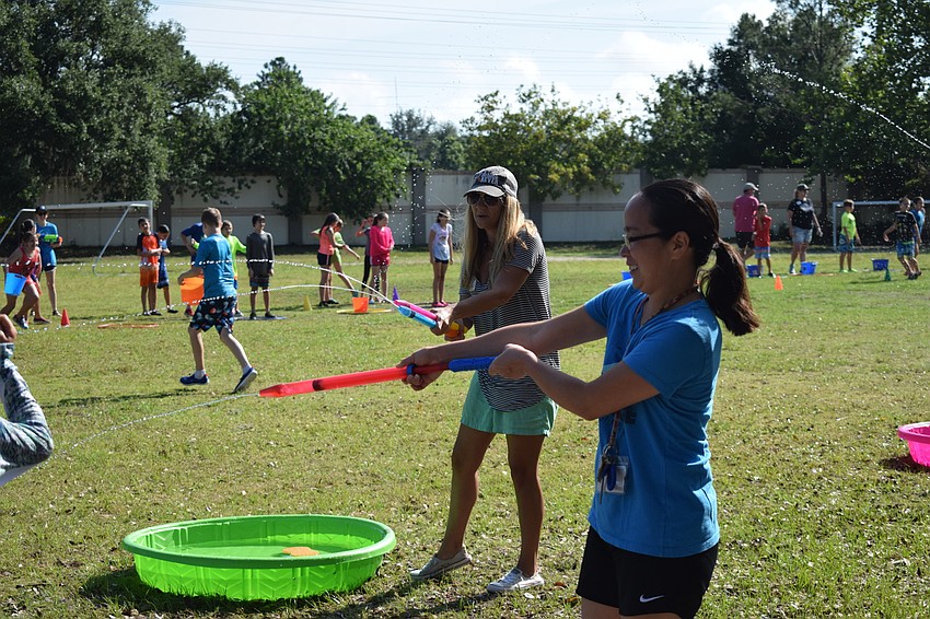Volunteer Regina Peterson and fourth grade teacher Michele Rzepa enjoyed spraying the kids with water to get them as wet as possible.