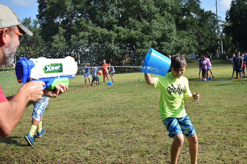 Nick Leduc, a fourth grade teacher, is unsuccessful in spraying fourth grader Jonathan Lopez, as he deflected the spray with his bucket.