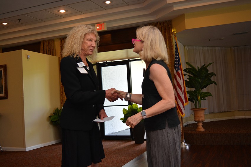 Hearing Loss Association of America Sarasota Manatee Chapter Board President Anne Taylor accepts a grant from Patti Sue Peotter-Bettes.